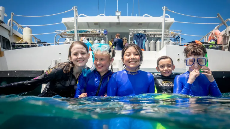 School kids at the back of a boat in the water